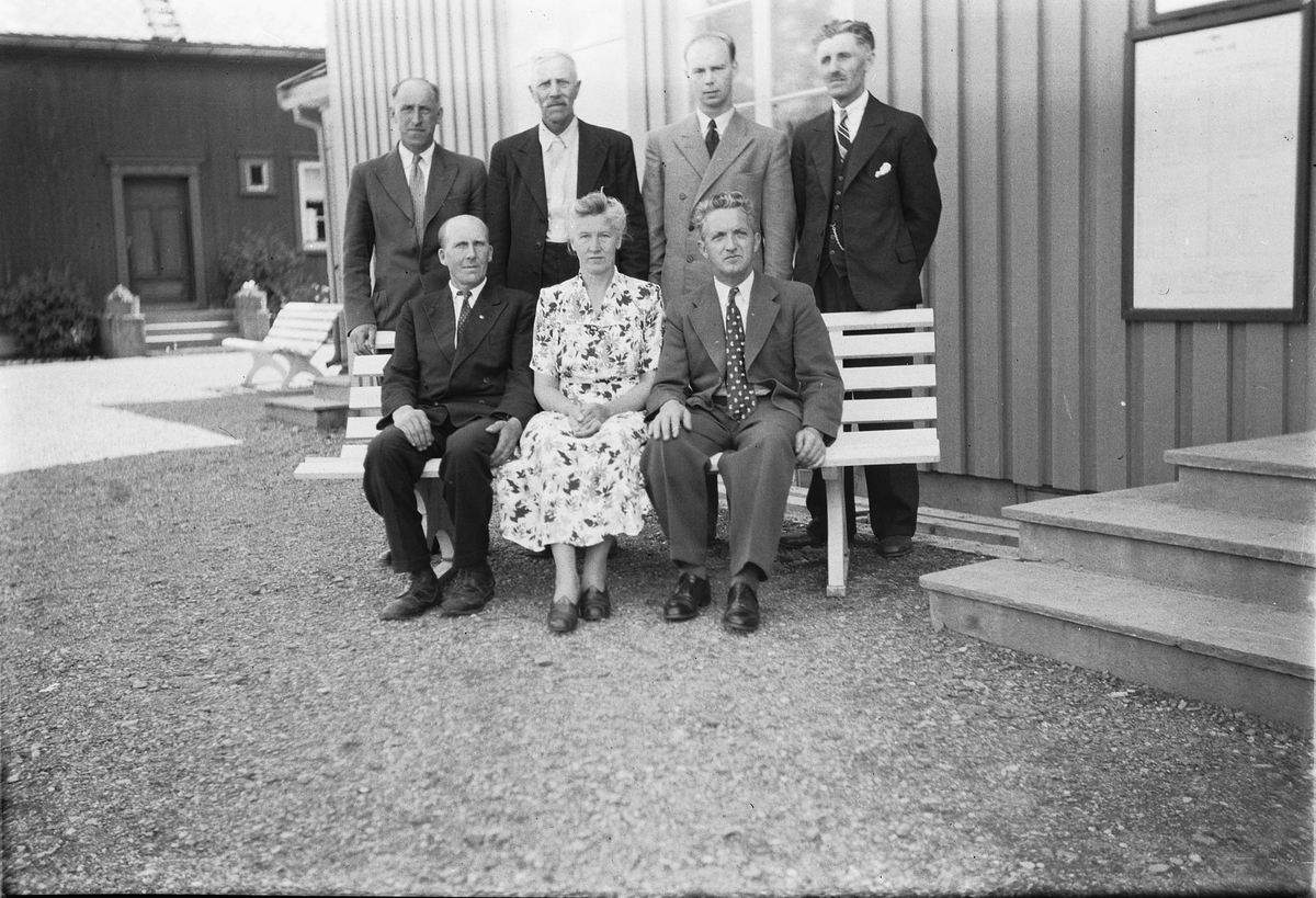 Håkon Prestkværn, Gruppe kvinner og menn foran et hus.