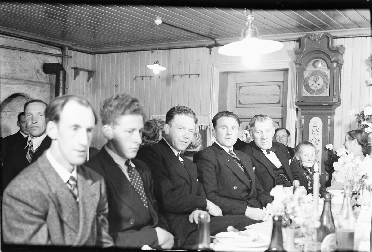 Håkon Prestkværn, Interiør med bestefar klokke. Ukjent familie samlet ved en festlig anledning.