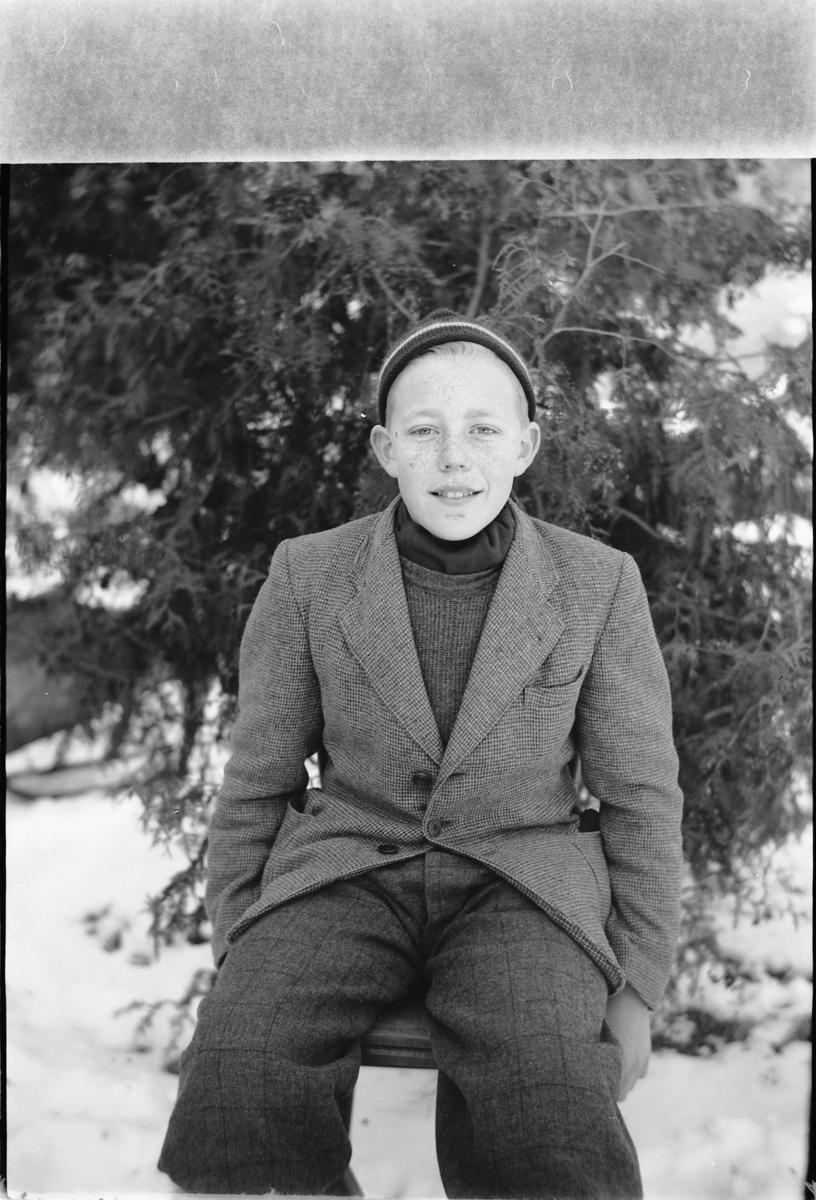 Håkon Prestkværn, Gutt med lue foran et grantre.
