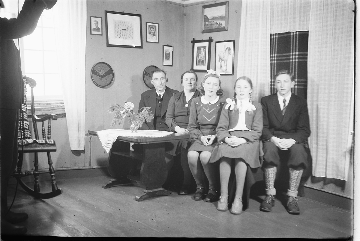 Håkon Prestkværn, Interiør, stue. Ukjent familiegruppe sitter i en sofa.