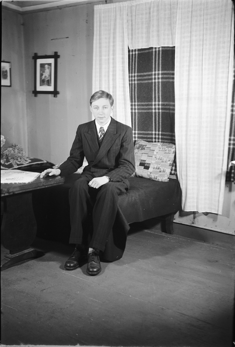 Håkon Prestkværn, Interiør, stue. Ukjent gutt med dress og slips.