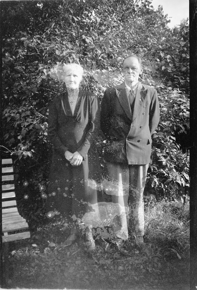 Håkon Prestkværn, Ukjent kvinne og mann ved en benk. Fotokonvolutt mrk. "Reppe m.m."