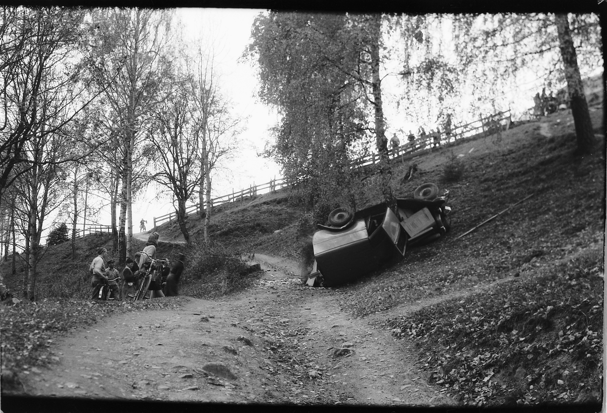 Håkon Prestkværn, Bilulykke. Varebil veltet i skråning. Moelv. John Strømman var uheldig og trillet ut over Lykkjebakken med sin fiskebil 1946-1947. Alt gikk imidlertid bra untatt med bilen en Opel P-4, D-3357, som nærmest ble vrak. Minda Kleiven står t. v. med sykkel.