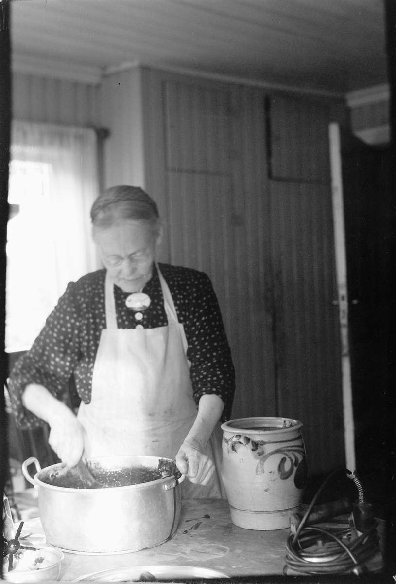 Håkon Prestkværn, Eldre kvinne sylter bær. Gunda Prestkværn koker syltetøy, kjele, krukke.