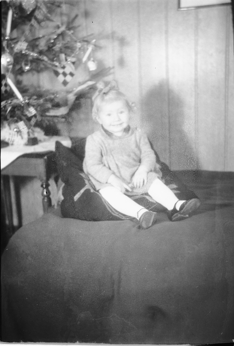 Håkon Prestkværn, Interiør, stue med juletre. Ei jente sitter i en sofa. "fotokonvolutt mrk. Aaseth julen 1948"