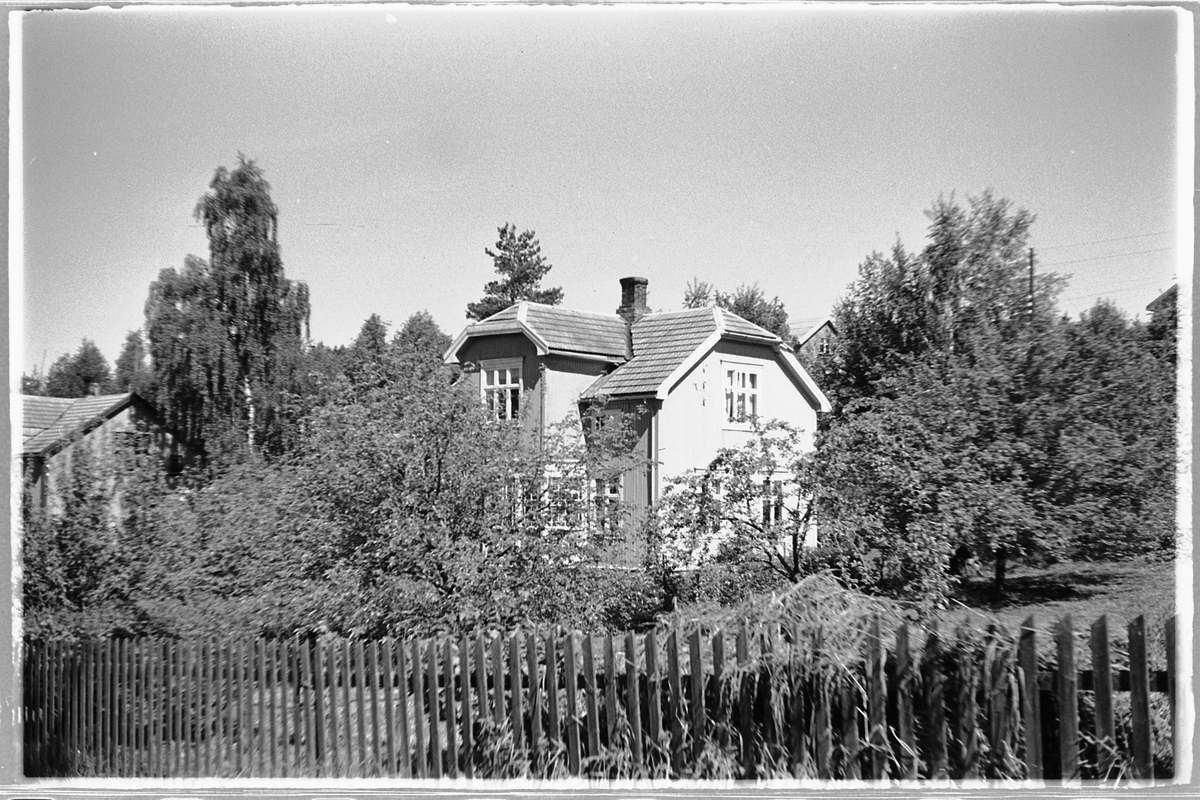 Håkon Prestkværn, Huset til familien Mostue i Jensstuvegen, Moelv. hus med hage og gjerde.