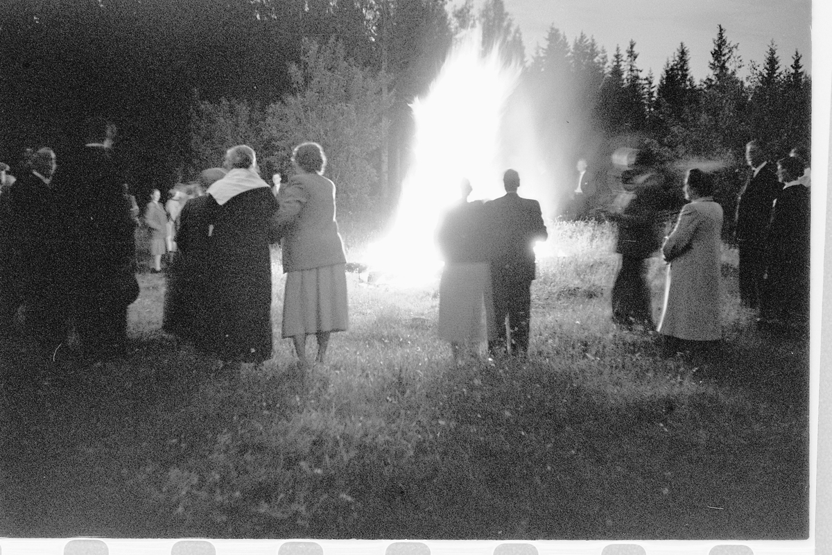 Håkon Prestkværn, Eksteriør. Gruppe mennesker samlet rundt et bål.