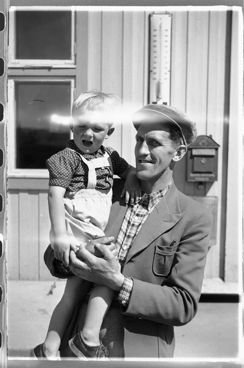 Håkon Prestkværn, Ukjent mann holder en gutt i armene.