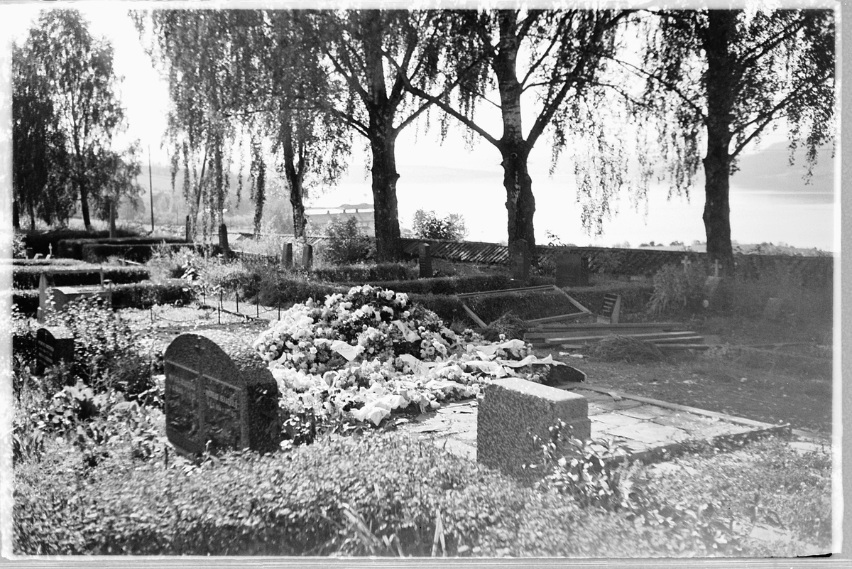 Håkon Prestkværn, En ny grav med blomsterkranser på en kirkegård. Ringsaker.