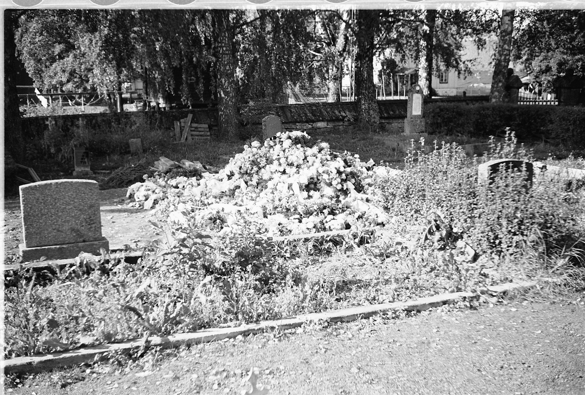 Håkon Prestkværn, En ny grav med blomsterkranser på en kirkegård.