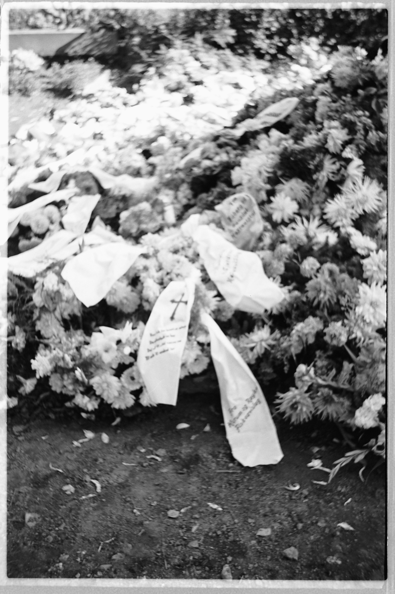 Håkon Prestkværn, En grav med blomsterkranser på en kirkegård.
