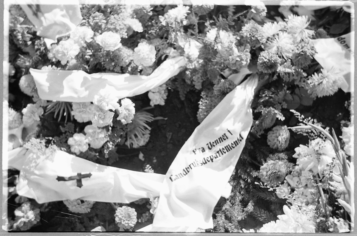 Håkon Prestkværn, En grav med blomsterkranser på en kirkegård.