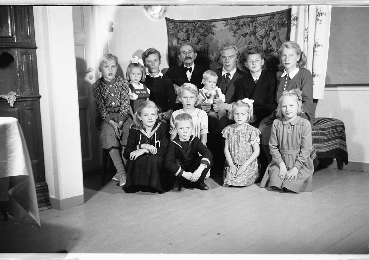 Håkon Prestkværn, Interiør, stue. Ukjent familiegruppe på en sofa.