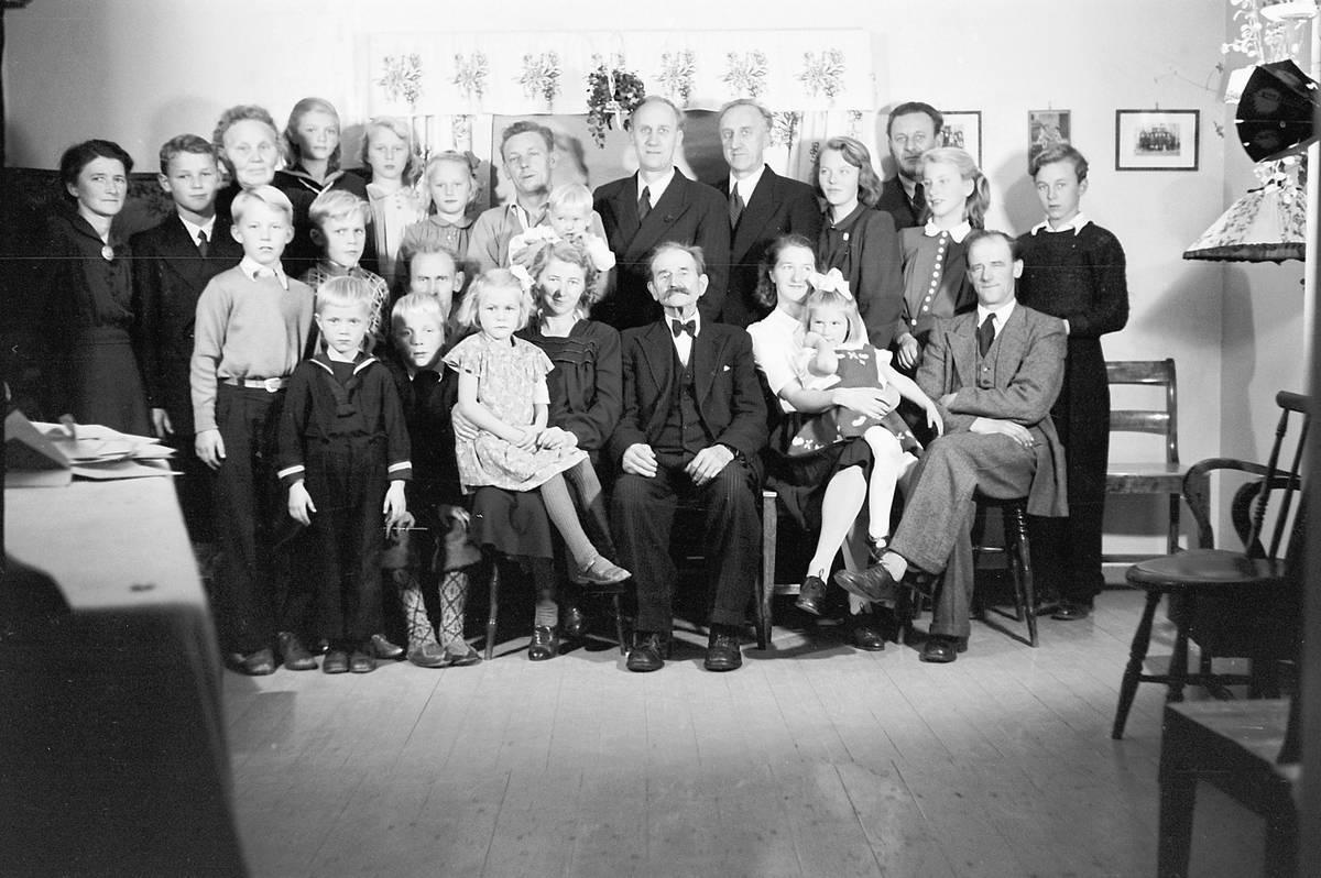 Håkon Prestkværn, Interiør, stue. Stor familiegruppe.