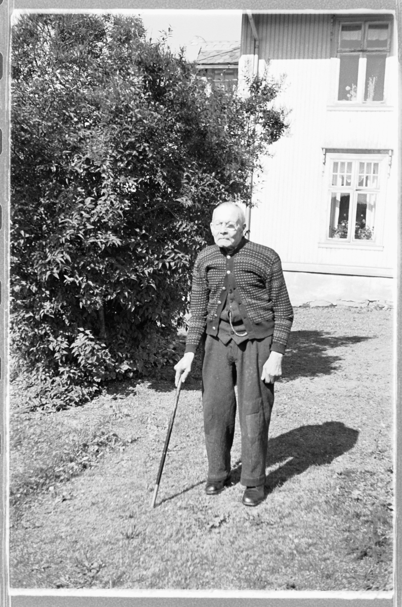 Håkon Prestkværn, Eksteriør, hage. Eldre mann med stokk.