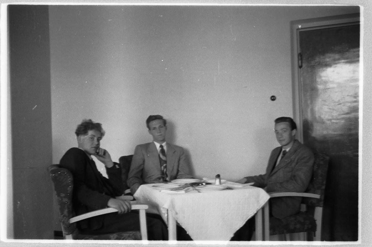 Håkon Prestkværn, Tre ukjente menn sitter rundt et bord.