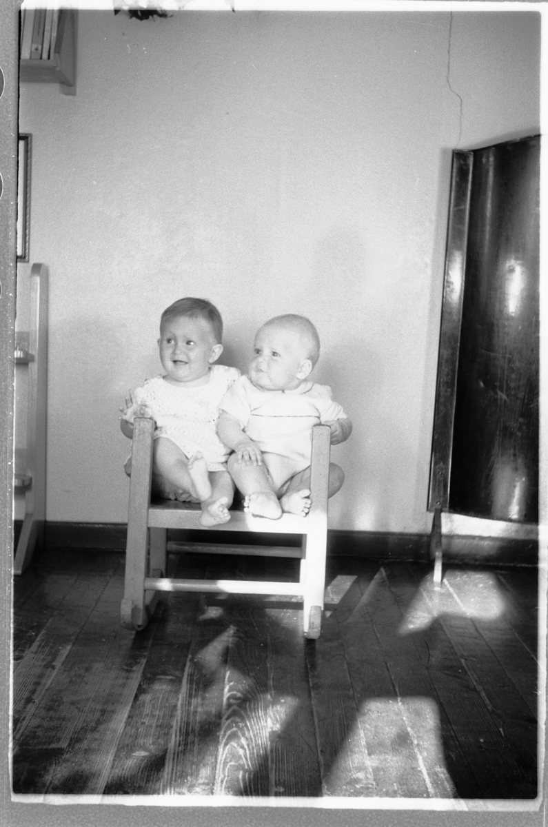 Håkon Prestkværn, Ei lita jente og en baby sitter i en stol.
