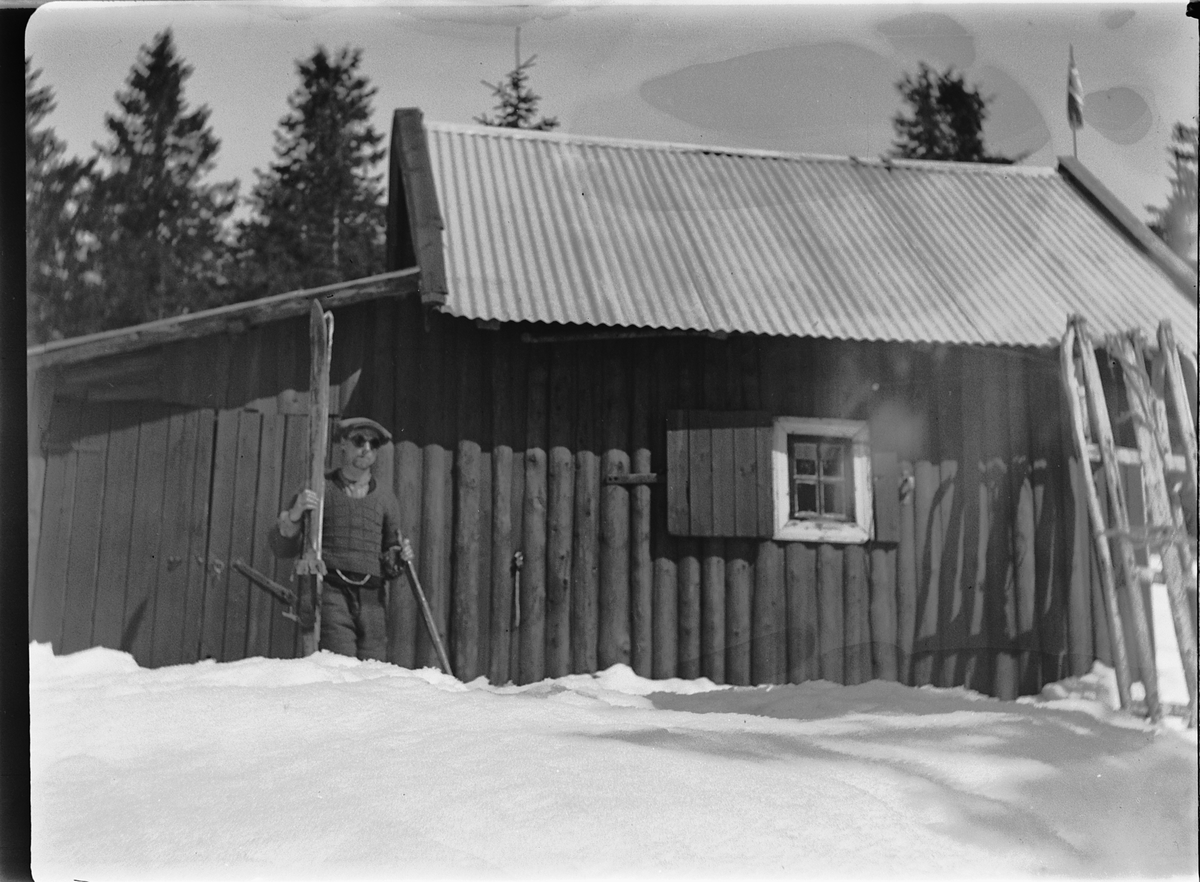 Ole M Martinsen, HYTTE, Solås. Ukjent mann med solbriller på ski. Hytta til Ole M. Martinsen (Spånestad) lå på Ruskåsen vest, Løten almenning. Det ble bygd ny hytte av familien Fuglebrenden på samme sted på 1970-tallet (Sportskapellet).