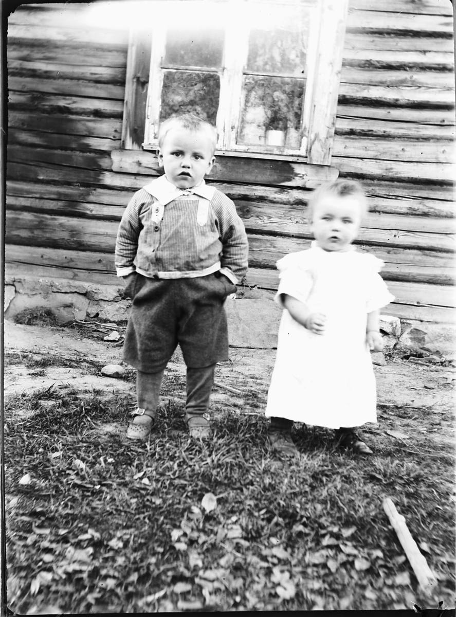 Ole M Martinsen, En liten gutt og jente utenfor et hus.