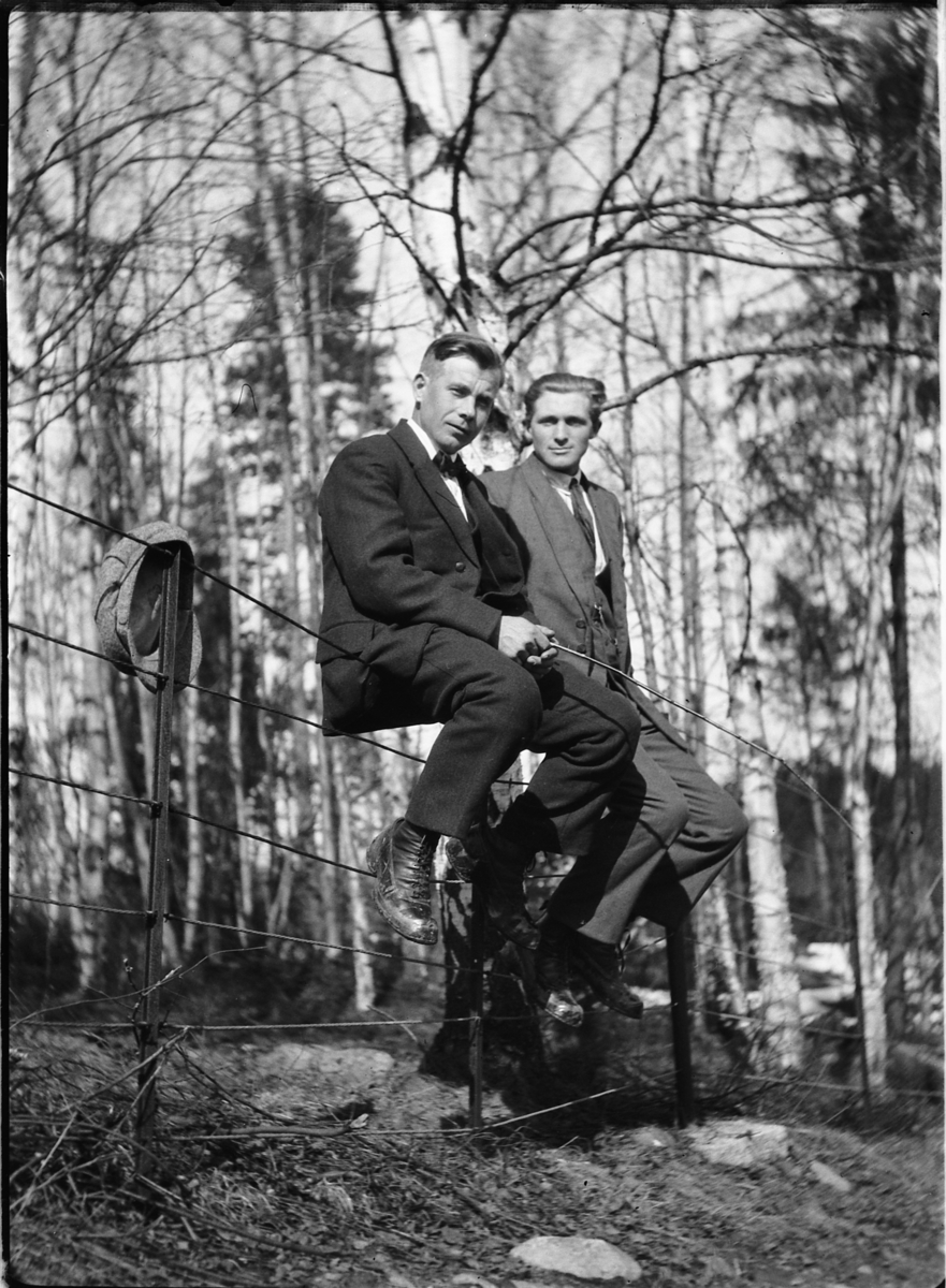 Ole M Martinsen, To menn i dress sitter på et gjerde.