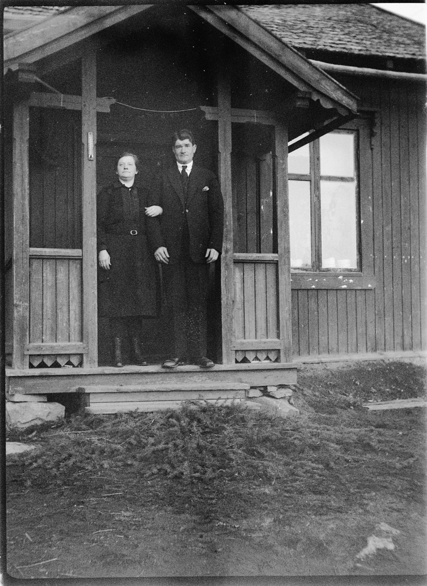 Ole M Martinsen, Ukjent kvinne og mann ved inngangsdør til hus.