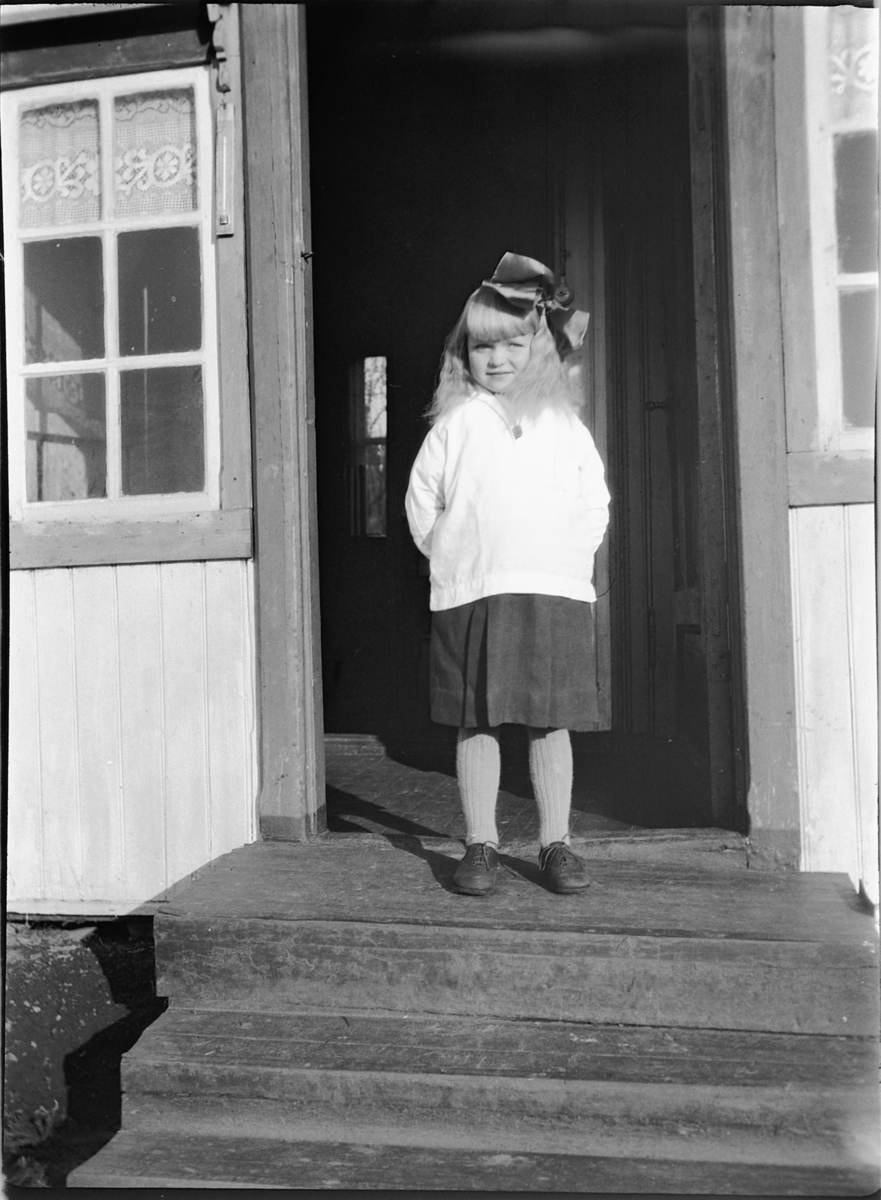 Ole M Martinsen, Hjørdis Talbak. (født ca 1920, d ca 1930) Jente med sløyfe i håret stående i døråpningen.