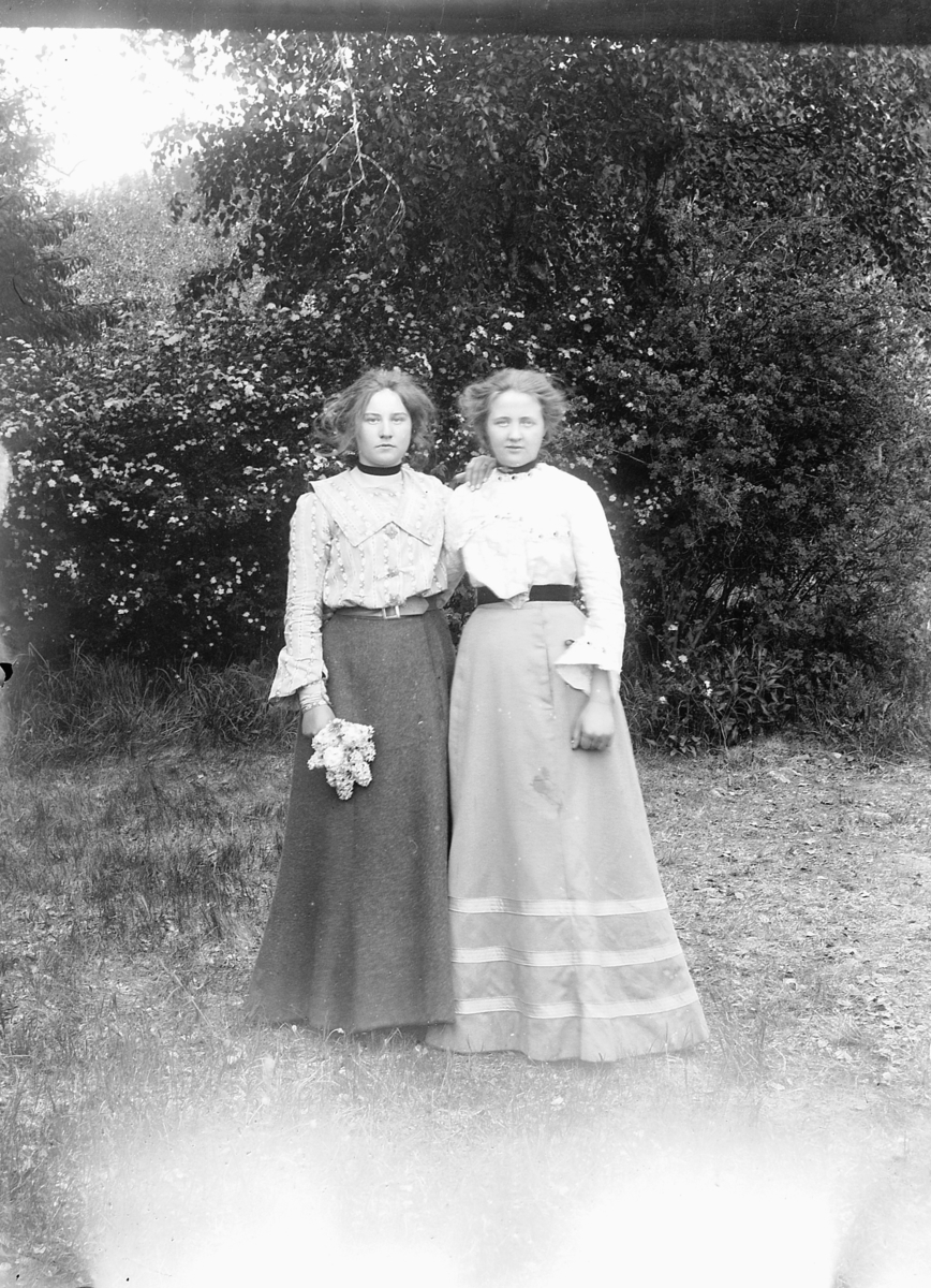Ragnvald Andersen, Eksteriør, hage. To ukjente kvinner, den ene holder blomster.