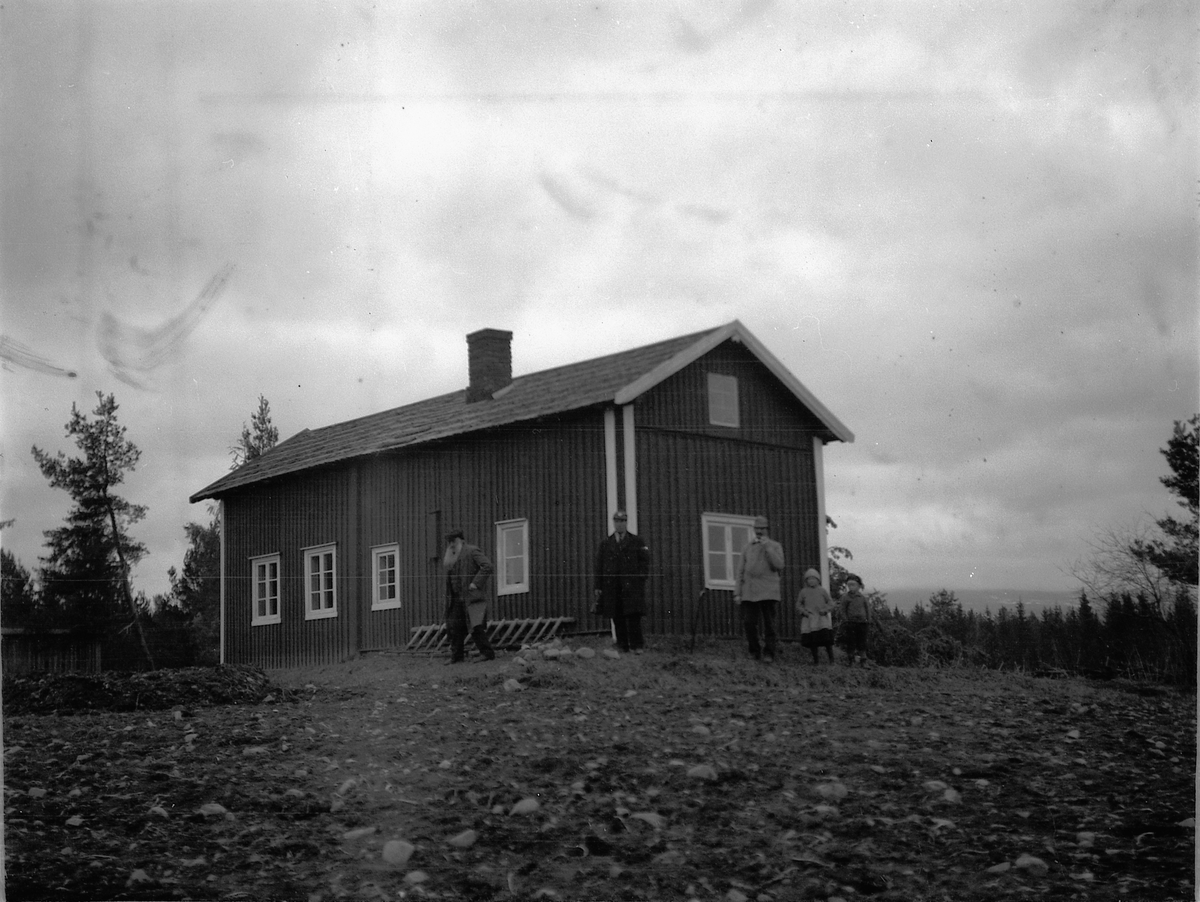 Ragnvald Andersen, Ukjent gruppe personer foran et hus.