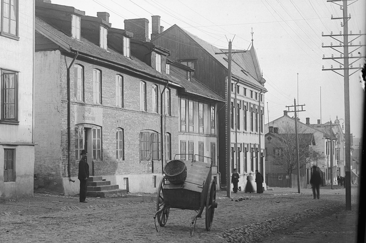 Hans Emil Erichsen, Grønnegata 61-63 i Hamar. Folk. Håndkjerre. Røverborgen til venstre.