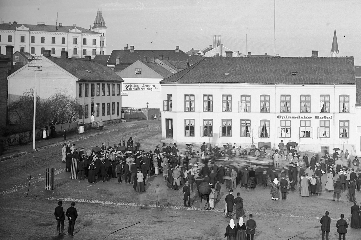 Hans Emil Erichsen, Stortorget i Hamar med Torggata. Oplandske Hotell. Mye folk på torget.