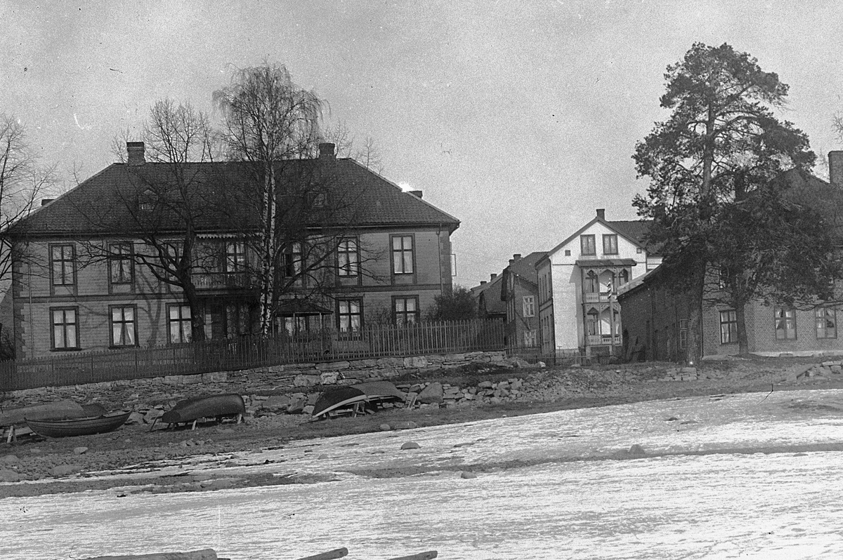 Hans Emil Erichsen, Ekely. Høiensalodden med Heidemannsgate 2 i Hamar. Vinterbilde. Robåter i vinteropplag i forgrunnen.