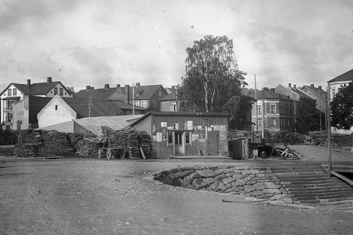 Hans Emil Erichsen, Hamar Brygge på Høiensalodden. Ekspedisjonslokale og vedlager. Bebyggelsen i Vestbyen i bakgrunn.