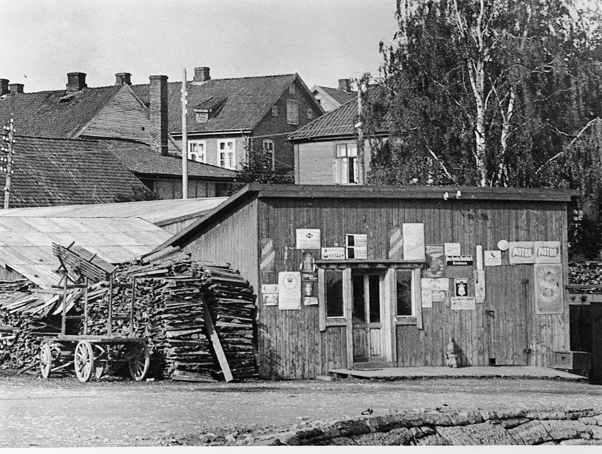 Hans Emil Erichsen, Hamar Brygge på Høiensalodden. Ekspedisjonslokale og vedlager. Bebyggelsen i Vestbyen i bakgrunn.