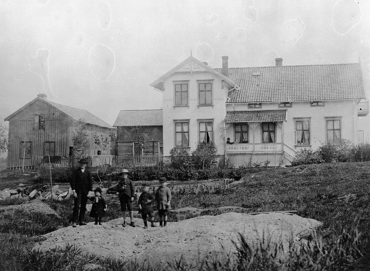 Hans Emil Erichsen, Parkggata 42 i Hamar, Negaards Hus. Barna til Hans Emil Erichsen. Jens, født 1886, Jacob, Johannes, født 1884 og Halvor, født 1882. Helt til venstre Erichsens gårdsgutt Ola Granberg. Bilde er tatt i 1889.