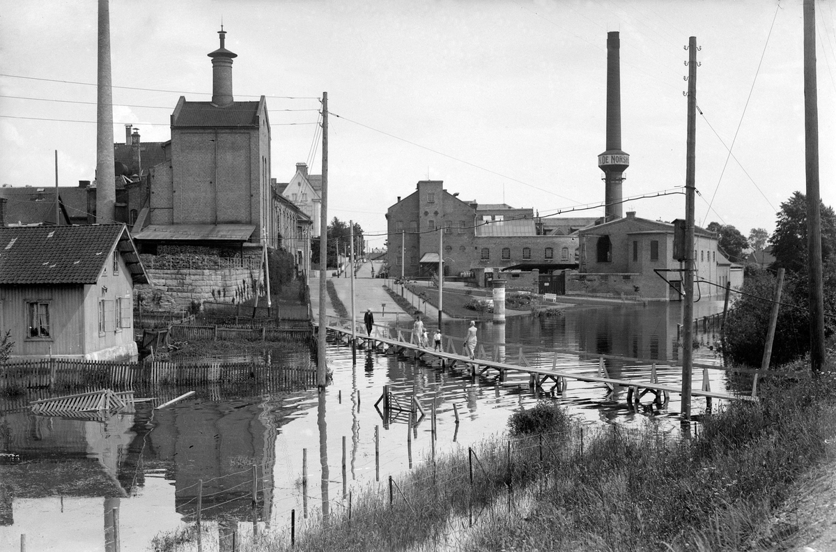 Oscar Løberg, Bryggeriundergangen i Hamar under flommen i 1927. Huset til venstre tilhørte Melkefabrikken og ble kalt "Boligen". Hamar Bryggeri.