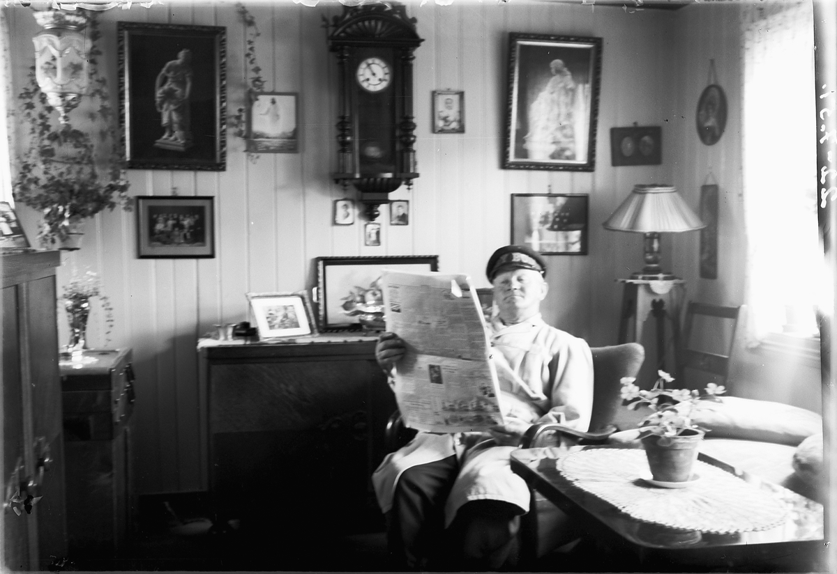 Simen Baardseth, Interiør, stue. Sjafør Hansell leser avisa. Hansellgården, Bjørgegården.