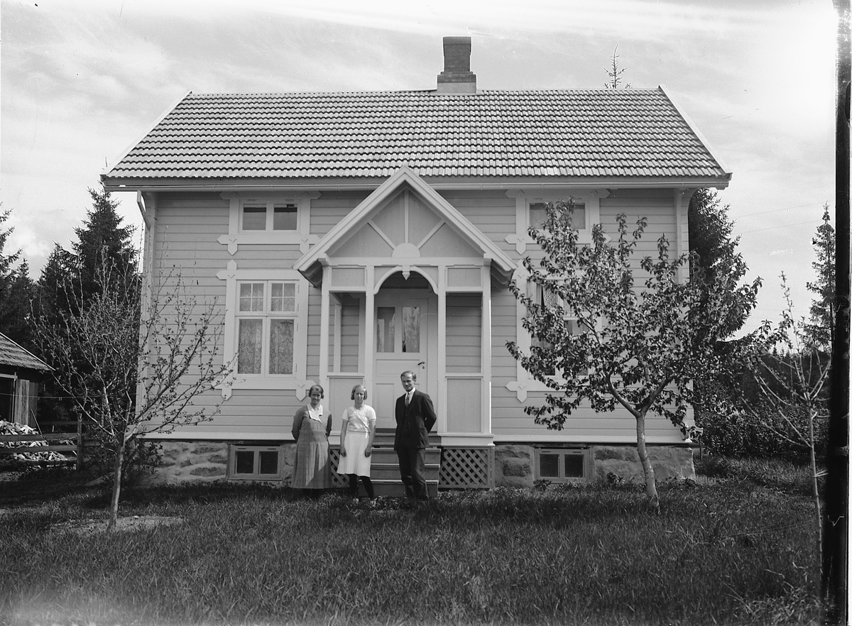 Simen Baardseth, Arne Sagmoen, med hustru og datter, foran huset sitt.