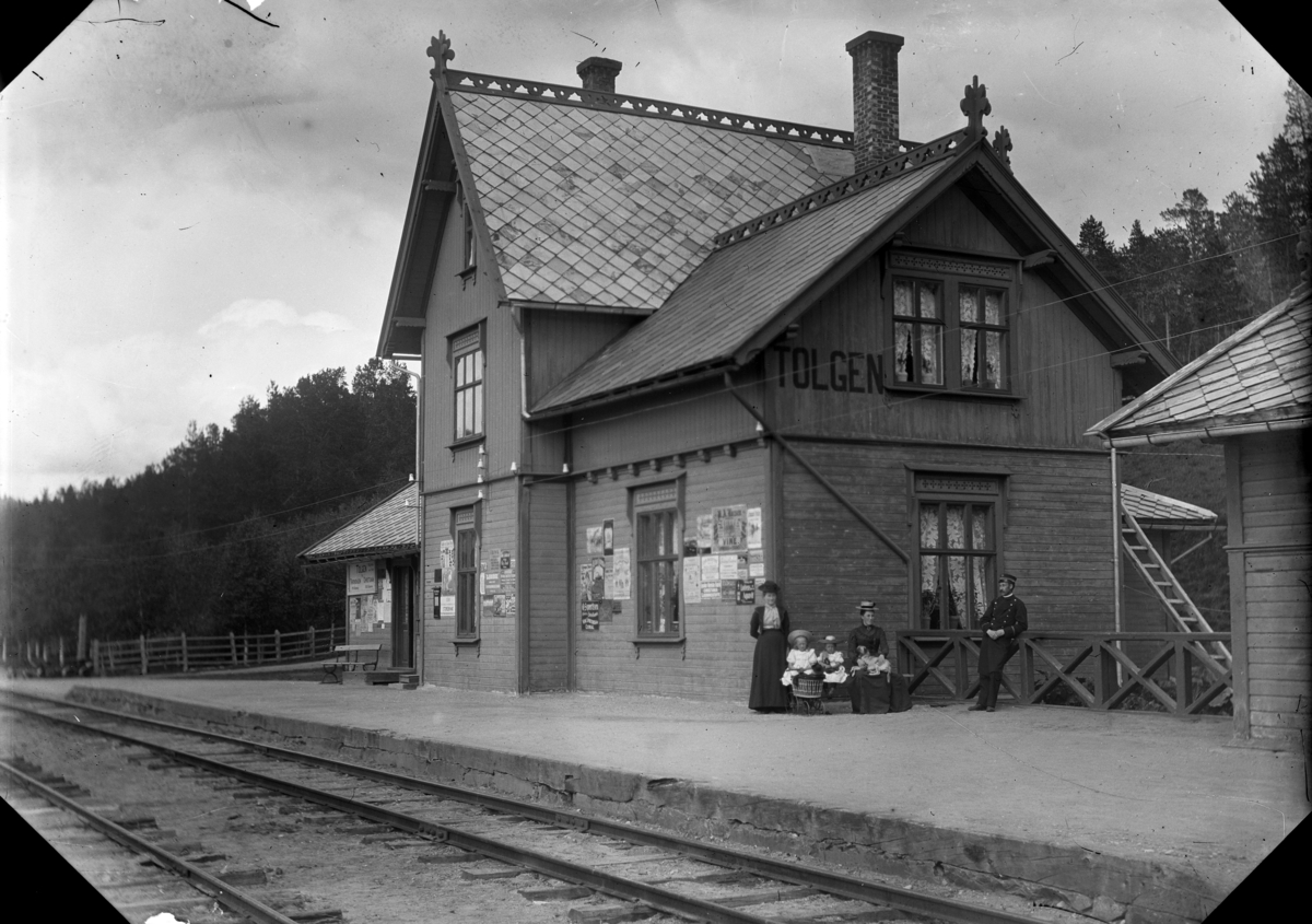Johannes Larsen Alhaug, Tolgen stasjon. To kvinner og to jenter sammen med en stasjonsmester. Den ene jenta har en dukkevogn. Tolga.