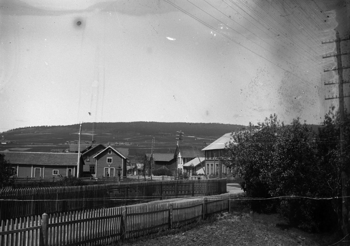 Johannes Larsen Alhaug, Tønset, Tynset. Utsikt fra annekset til jernbanehotellet nedover Brugata. Bygningen til høyre (R. Lunstøeng) brant i 1903.