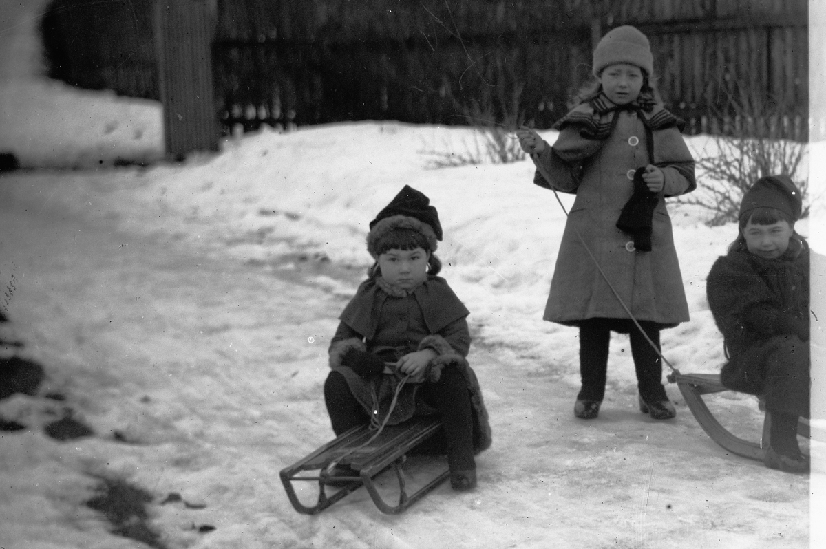 Hans Emil Erichsen, 3 ukjent småjenter i lek med kjelker.