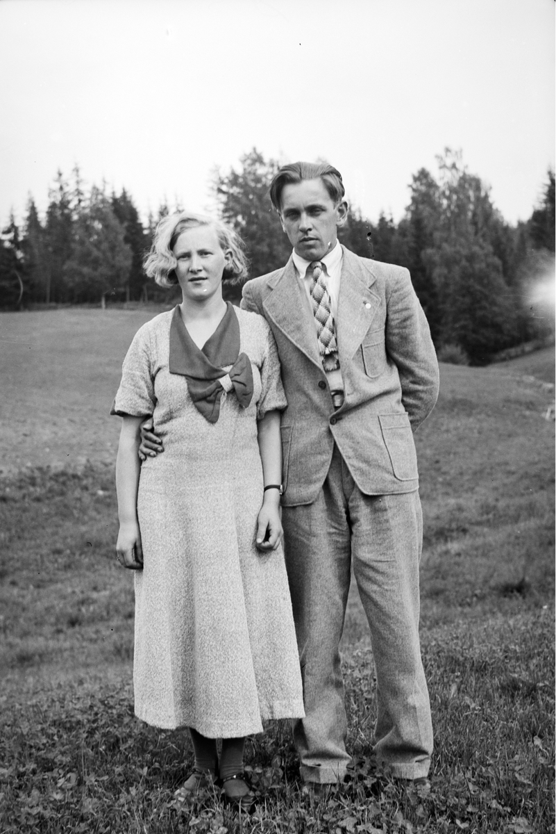 Håkon Prestkværn, ukjent kvinne og mann. Kjole og dress.