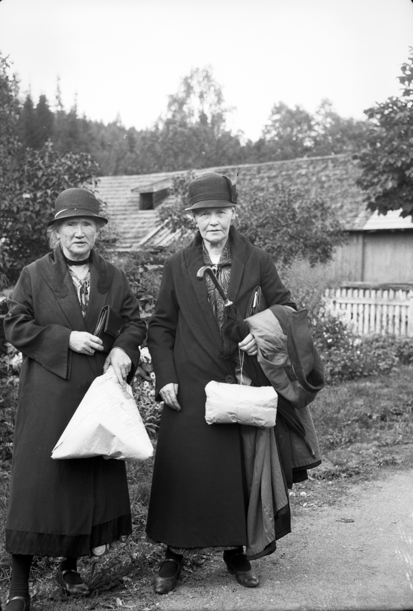 Håkon Prestkværn, To eldre kvinner, med pakker, gråpapir, avispapir, vesker, paraply, kvinneklær, handletur.