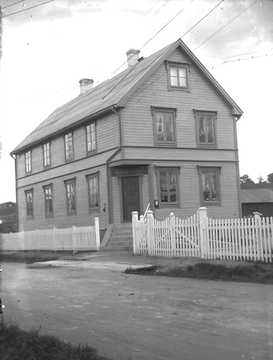 Per K. Lien, Stort hus med kobberslager-skilt over inngangsporten.
