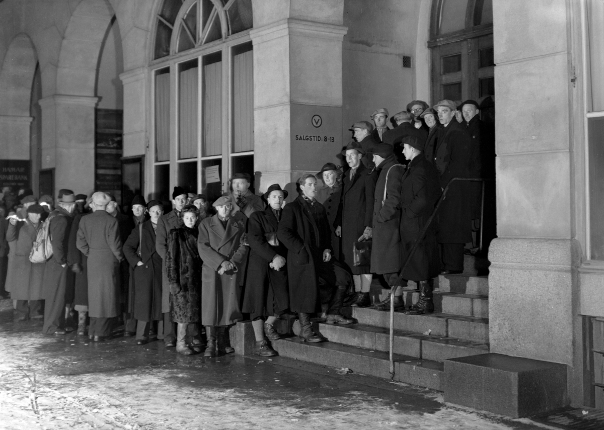 Normann Fotoatelier, Polkø utenfor Festiviteten under krigen. 23. 12. 1943. Strandgt. / Torggt. Hamar. Kl. 7 - 7. 30