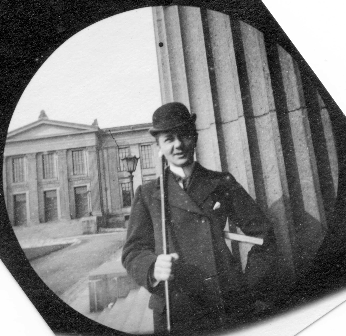 Fredrik Carl Mülertz Størmer, Student Jacob Bisgaard med hatt, frakk, stokk og bok under armen på trappa til Universitetet, Oslo.