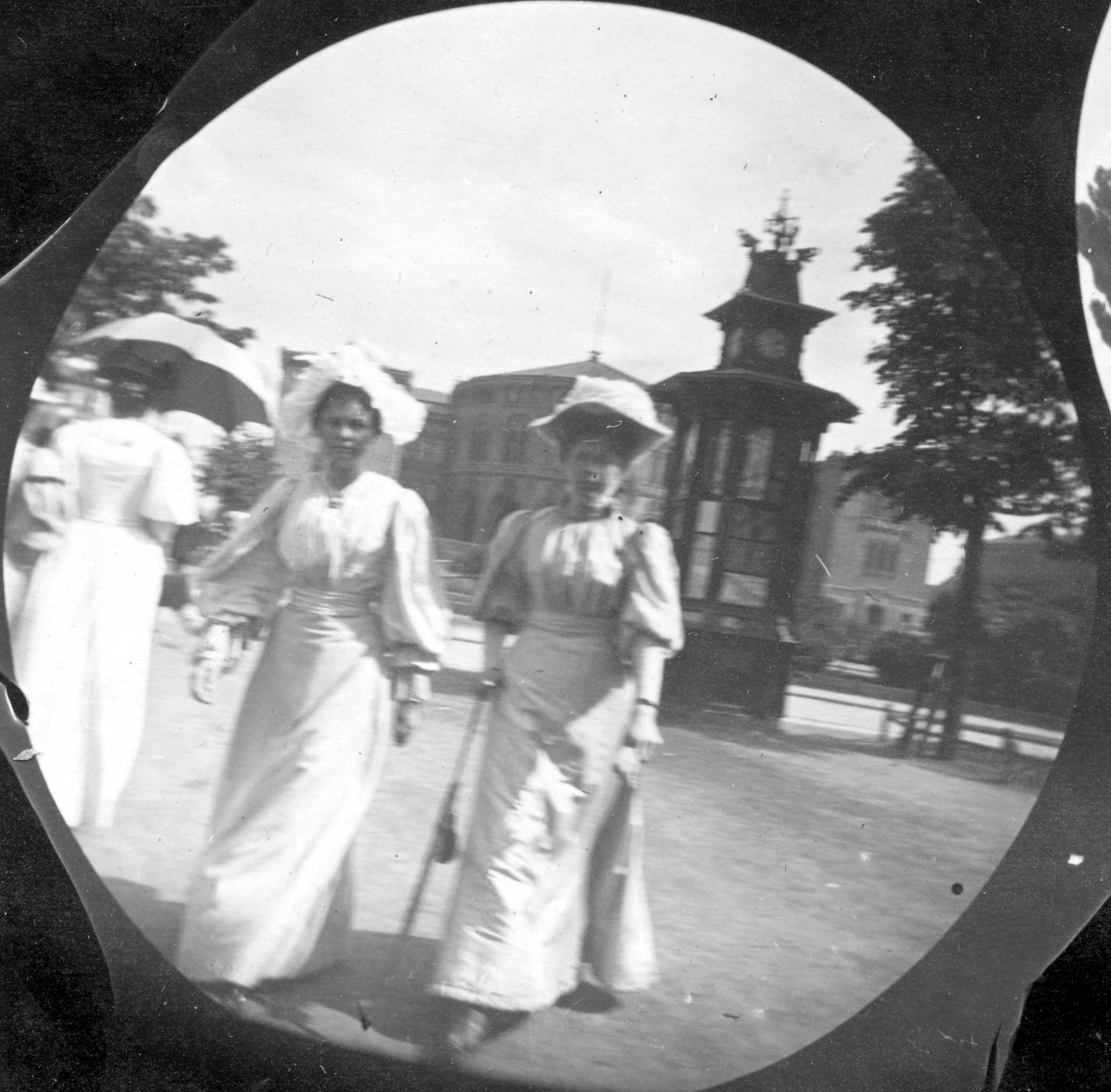 Fredrik Carl Mülertz Størmer, Frk. Ragnhild Welhaven og frk. Thora Christoffersen foran Stortinget. Kiosk med klokketårn.