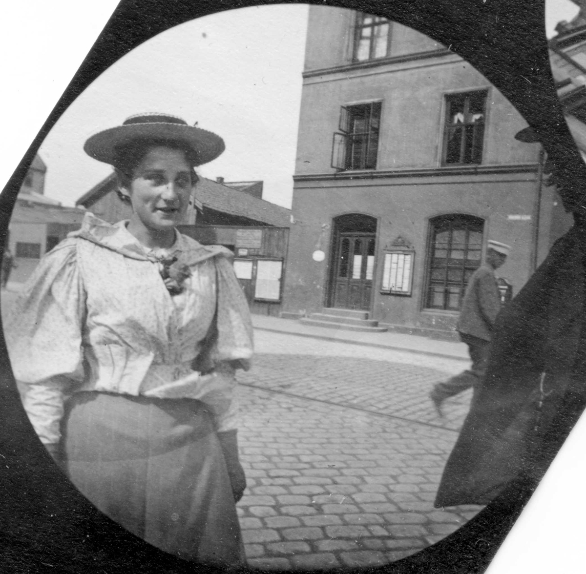 Fredrik Carl Mülertz Størmer, Frk. Collet, senere gift med professor Thue, står i bygate. Mur bygård og lave verkstedsbygninger.
