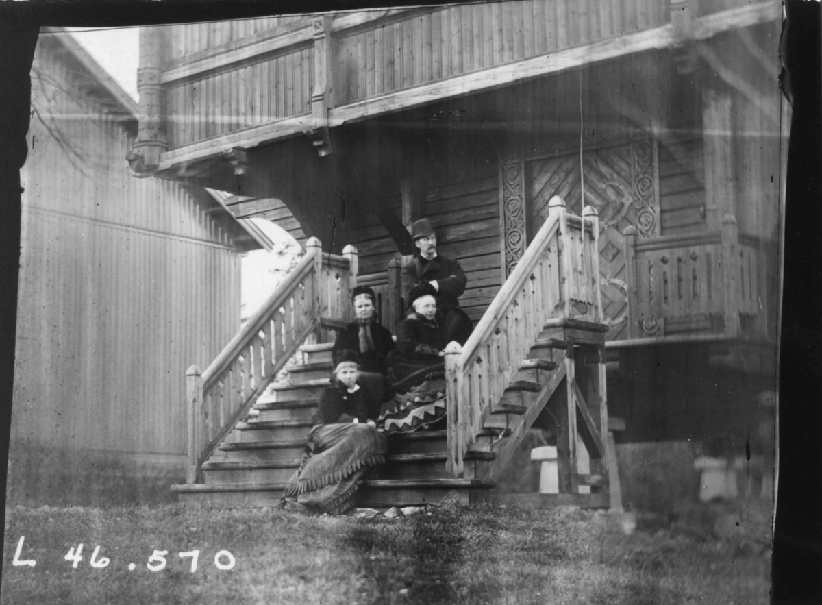 Fredrik Emil Faye, Gruppeportrett, på trapp til loftsbygning hos sorenskriver Platou, Plukstad, Romerike, med medlemmer av familien Platou, ca. 1880. Fru Sigrid Faye sitter nederst. Fra portrettserie av personer som bodde på eller besøkte Dal gård, Ullensaker, fotografert av gårdens eier, kammerherre Fredrik Emil Fay…