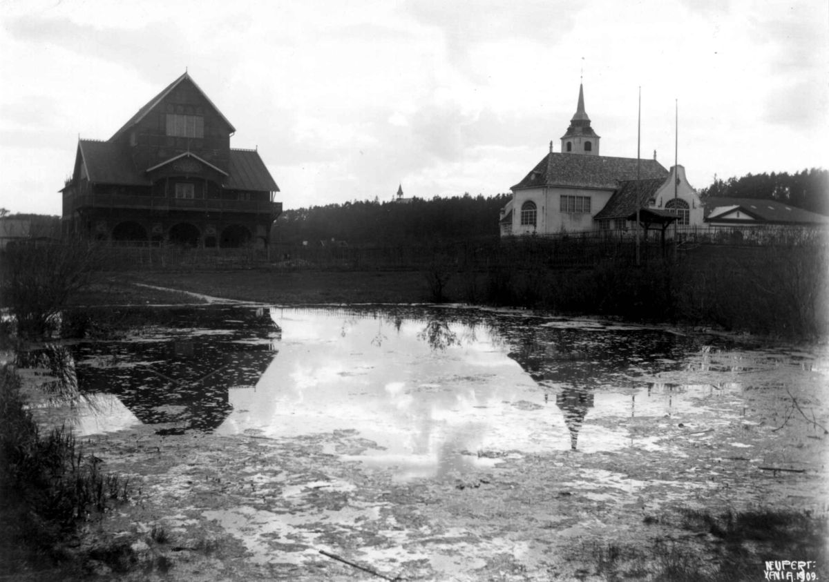 Hermann Christian Neupert, Norsk Folkemuseum, Oslo. 1909. Fra venstre Pariserpaviljongen fra Verdensutstillingen i Paris 1900 (revet) og Kirken (revet). Dam i forgrunnen.