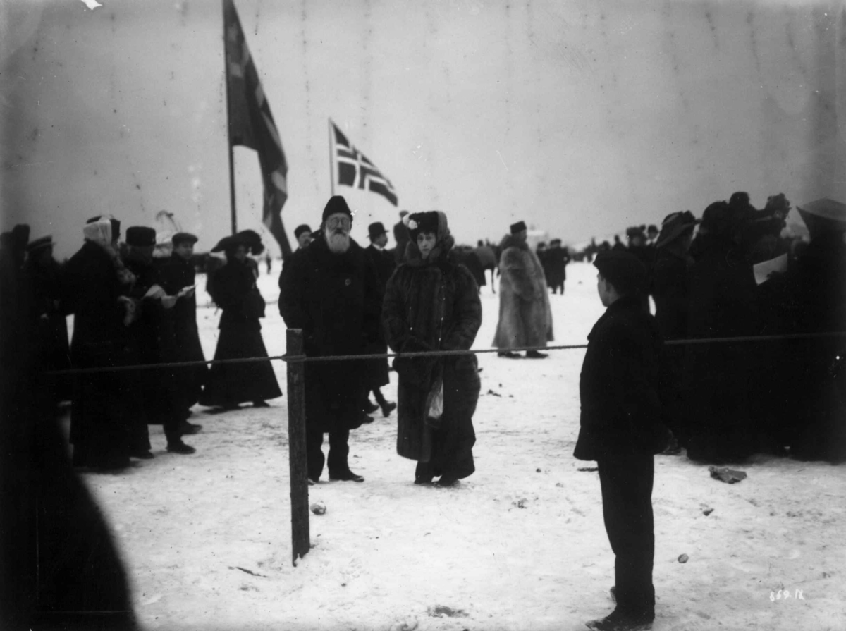 Hermann Christian Neupert, Frognerkilen, Oslo 1909. Vintermotiv. Fra kappritt. Dronning Maud i samtale med hoffjegermester Fearnley. Publikum.